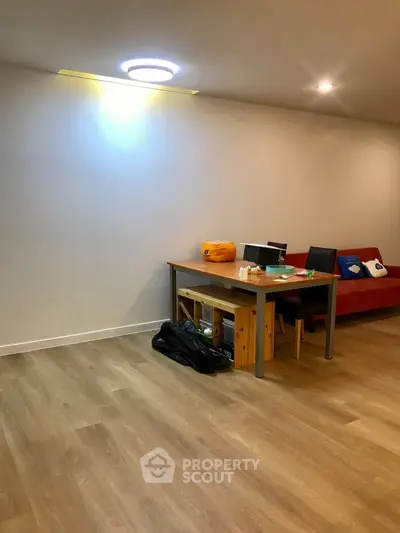 Spacious living room with modern wooden flooring and cozy furniture setup.