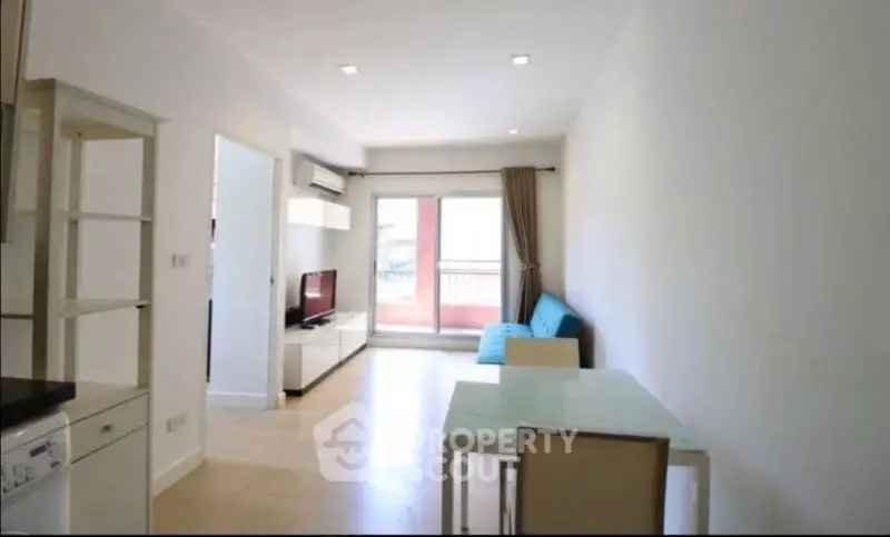 Bright modern living room with balcony access and sleek furniture.