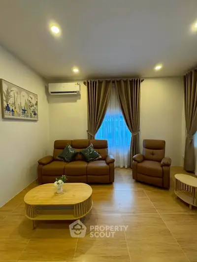 Cozy living room with modern brown leather sofa set and elegant curtains, perfect for relaxation.