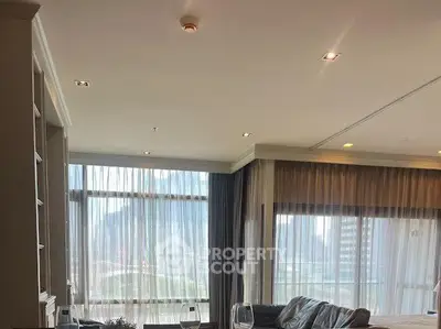 Spacious living room with large windows and city view