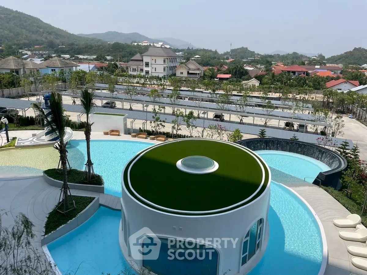 Luxurious poolside view with modern architecture and scenic mountain backdrop.