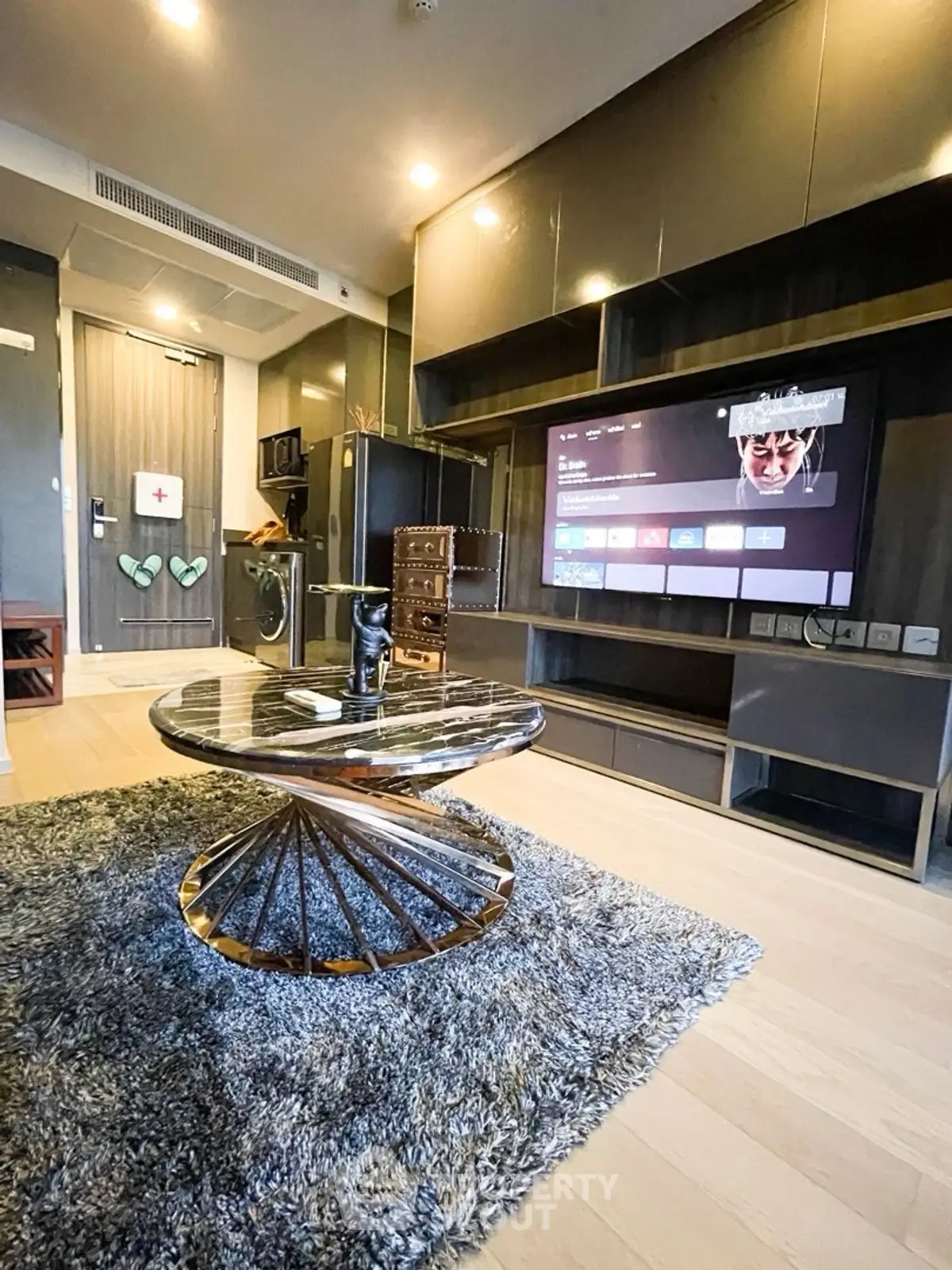 Modern living room with sleek furniture and large TV, perfect for entertainment.