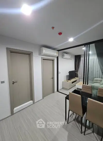 Modern living room with sleek design, featuring air conditioning and stylish dining area.