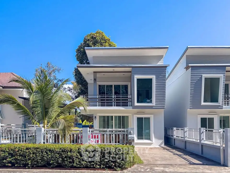 Modern two-story house with sleek design and spacious driveway in sunny neighborhood.