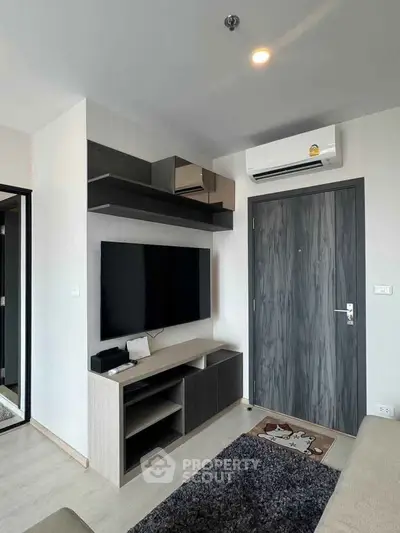 Modern living room with sleek TV unit and air conditioning in a stylish apartment.