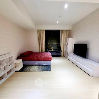 Spacious modern bedroom with large TV and stylish decor