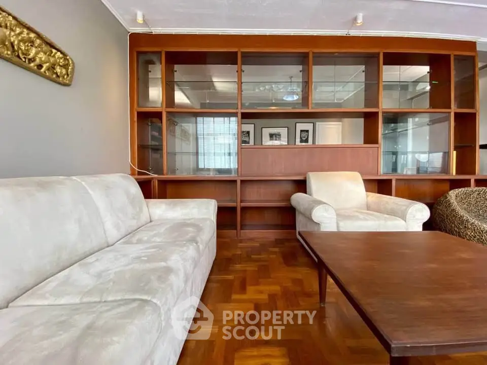 Spacious living room with elegant wooden shelving and plush seating, perfect for relaxation and entertainment.