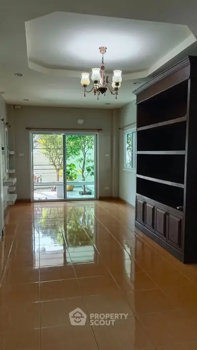 Spacious living room with elegant chandelier and garden view