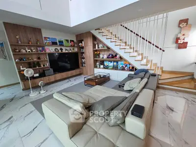Spacious modern living room with stylish decor and open staircase, perfect for family gatherings.