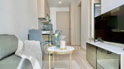 Modern living room with sleek furniture and open kitchen layout in a stylish apartment.