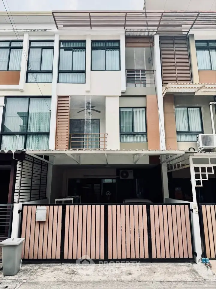 Modern townhouse exterior with sleek design and gated entrance