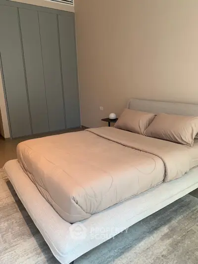 Modern bedroom with sleek design and neutral tones, featuring a cozy bed and stylish wardrobe.