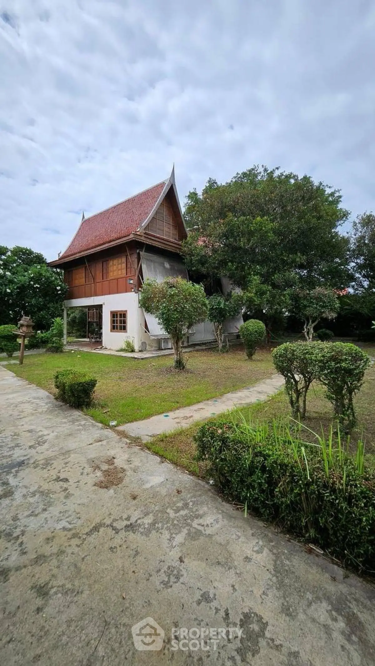 Charming traditional house with lush garden and unique architectural design.