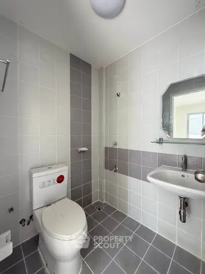 Modern bathroom with sleek tiles and contemporary fixtures in a real estate property.