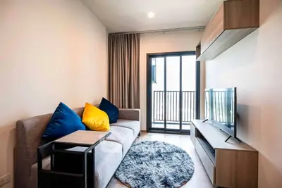 Modern living room with cozy sofa, stylish decor, and balcony access in a chic apartment.