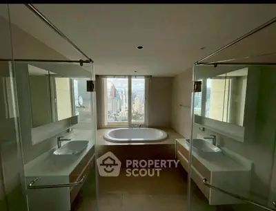 Luxurious bathroom with dual sinks and a bathtub offering stunning city views.