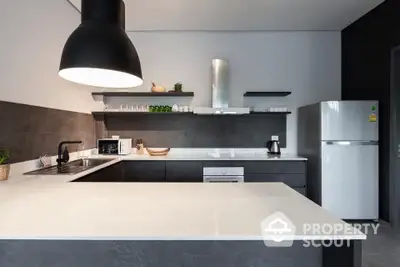 Modern kitchen with sleek design, featuring a large countertop, built-in oven, and stylish lighting.