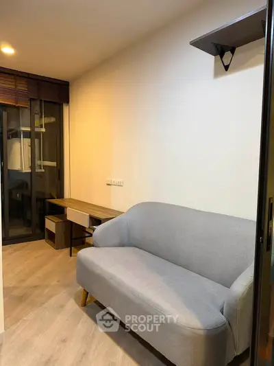 Cozy living room with modern gray sofa and wooden flooring, perfect for relaxation.