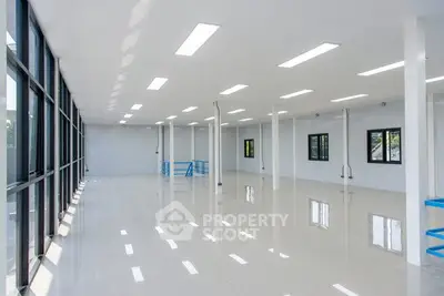 Spacious open-plan commercial space with large windows and polished floors