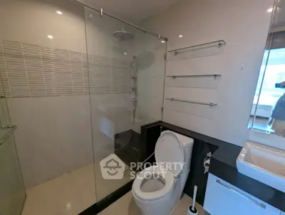 Modern bathroom with glass shower and sleek fixtures in a contemporary apartment.