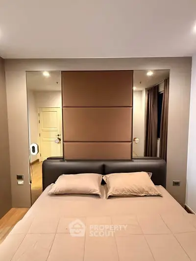 Luxurious bedroom with elegant decor and plush bedding in modern apartment.