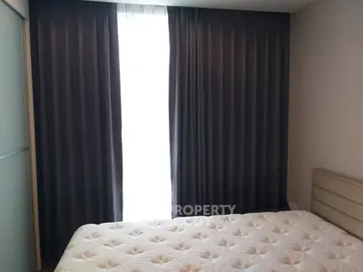 Cozy bedroom with plush mattress and elegant curtains