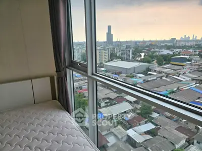 High-rise apartment bedroom with panoramic city view through large windows.