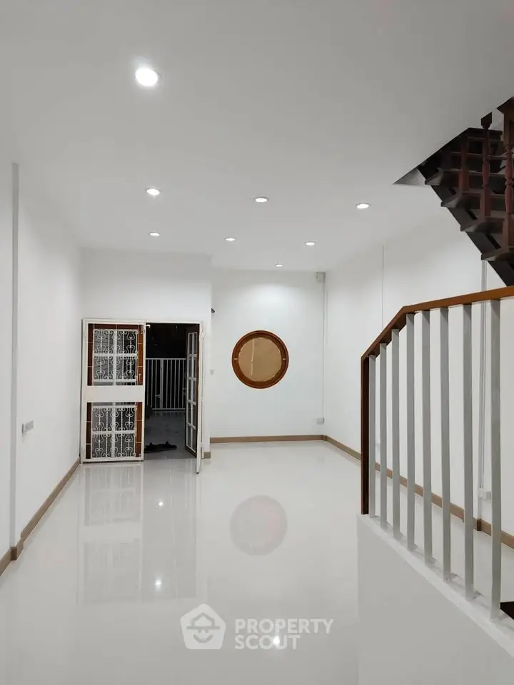 Spacious modern living room with sleek staircase and bright lighting