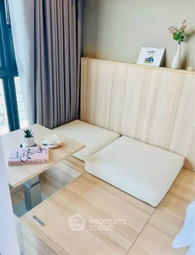 Cozy modern living space with minimalist wooden seating and natural light.