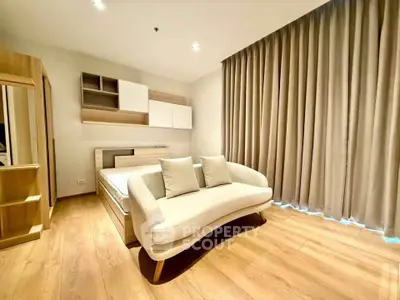 Spacious modern bedroom with elegant wooden flooring and cozy sofa