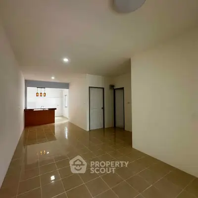 Spacious open-plan living area with tiled flooring and modern kitchen