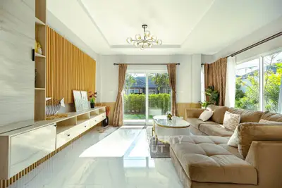 Spacious living room with modern decor and large windows offering garden view