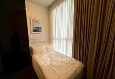 Cozy bedroom with elegant curtains and framed artwork, perfect for relaxation.