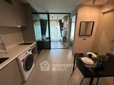 Modern apartment interior with open kitchen and cozy living area, featuring sleek appliances and stylish decor.