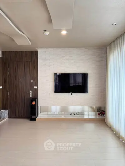 Modern living room with stylish ceiling, wall-mounted TV, and floor-to-ceiling curtains.