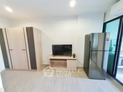 Modern living room with sleek TV stand and large refrigerator
