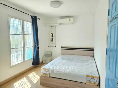 Bright bedroom with large window, air conditioning, and minimalist decor