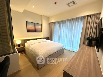 Modern bedroom with cozy lighting and large window in stylish apartment.
