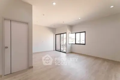 Spacious empty room with large windows and wooden flooring