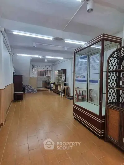 Spacious interior with wooden flooring and display cabinets, ideal for commercial use or storage.