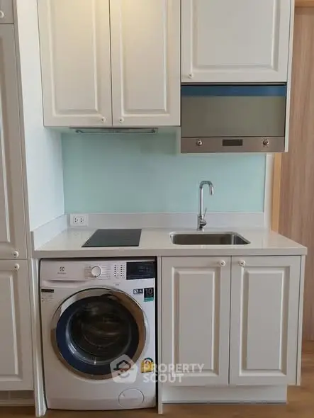 Modern kitchen with washing machine and sleek cabinetry