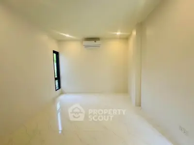 Spacious empty room with modern air conditioning and large window, perfect for customization.