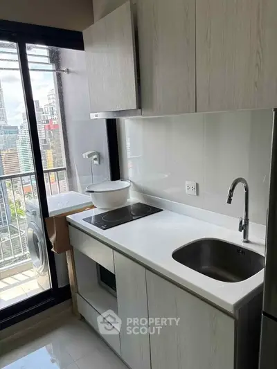 Modern kitchen with sleek cabinetry and city view from balcony