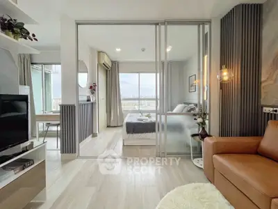 Modern apartment interior with open living room and bedroom, featuring stylish decor and natural light.
