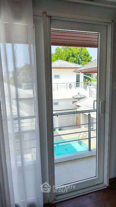 Bright balcony view overlooking a modern house with a pool
