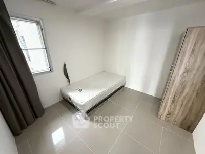 Minimalist bedroom with single bed and wardrobe, perfect for cozy living.