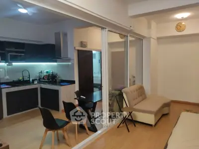Modern open-layout living room with sleek kitchen and cozy seating area.