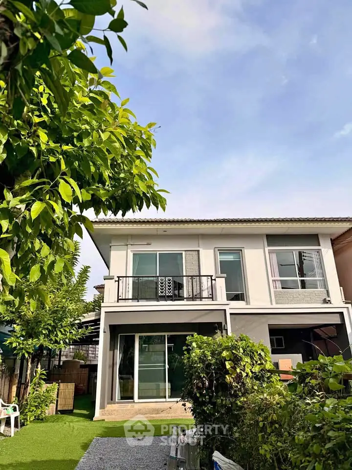 Charming two-story house with lush garden and balcony, perfect for family living.