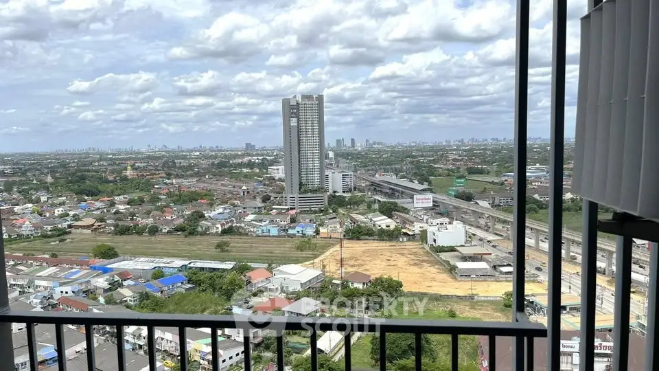 Stunning cityscape view from a high-rise balcony overlooking urban landscape and distant skyline.