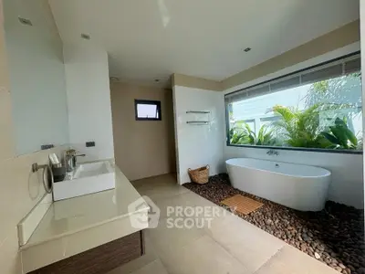 Luxurious bathroom with freestanding tub and garden view, featuring modern fixtures and elegant design.